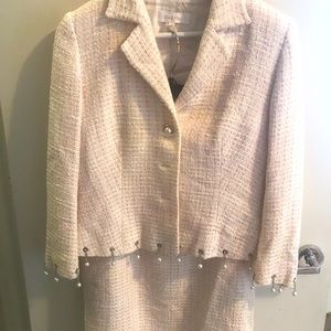 Pastel Escalade suit with pearls on short chains adorning the jacket bottom